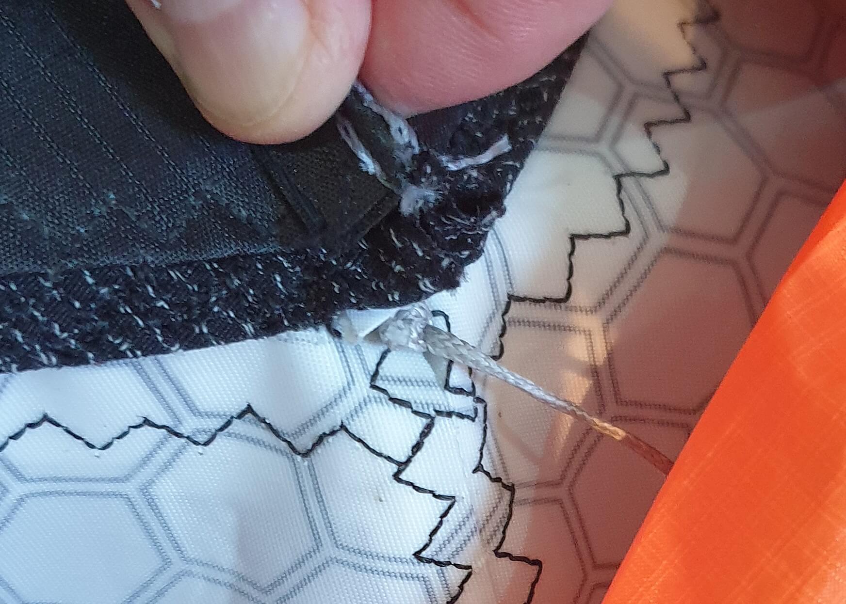 Strut bladder nose seated inside the strut fabric, locking line through nose hole with light tension, no TPU visible, centered nose section